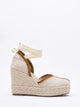 Sandalias de cuña en yute trenzado con cintas al tobillo.