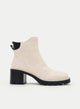Botins bege com salto largo e detalhe preto.