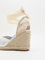 Silver wedge espadrilles with esparto sole and ribbons to tie at the ankle.
