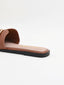 Flat brown sandals with gold buckle and square toe.