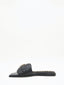 Sandalias negras planas con hebilla dorada y puntera cuadrada.