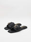 Sandalias negras planas con hebilla dorada y puntera cuadrada.