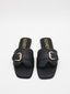 Sandalias negras planas con hebilla dorada y puntera cuadrada