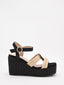 Sandalias de cuña alta en rafia negra y beige con plataforma y tiras cruzadas. Modernas, cómodas y versátiles.