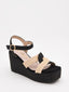 Sandalias de cuña alta en rafia negra y beige con plataforma y tiras cruzadas. Modernas, cómodas y versátiles.