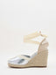 Silver wedge espadrilles with esparto sole and ribbons to tie at the ankle.